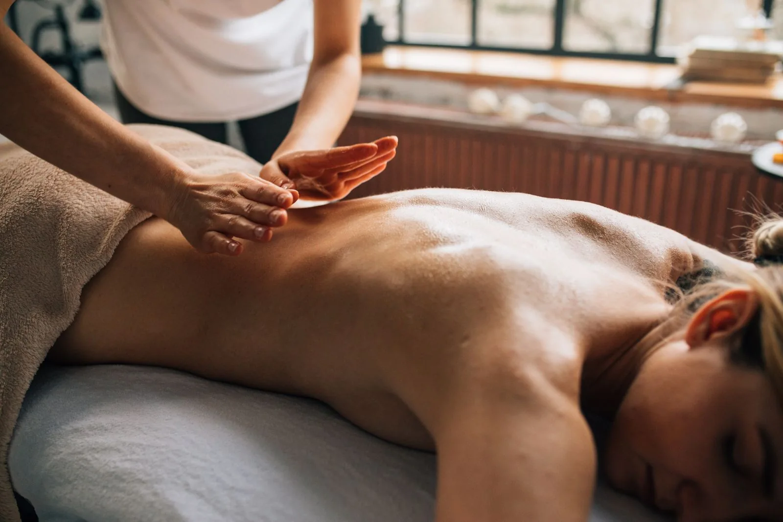 Hands working across the upper back during a massage