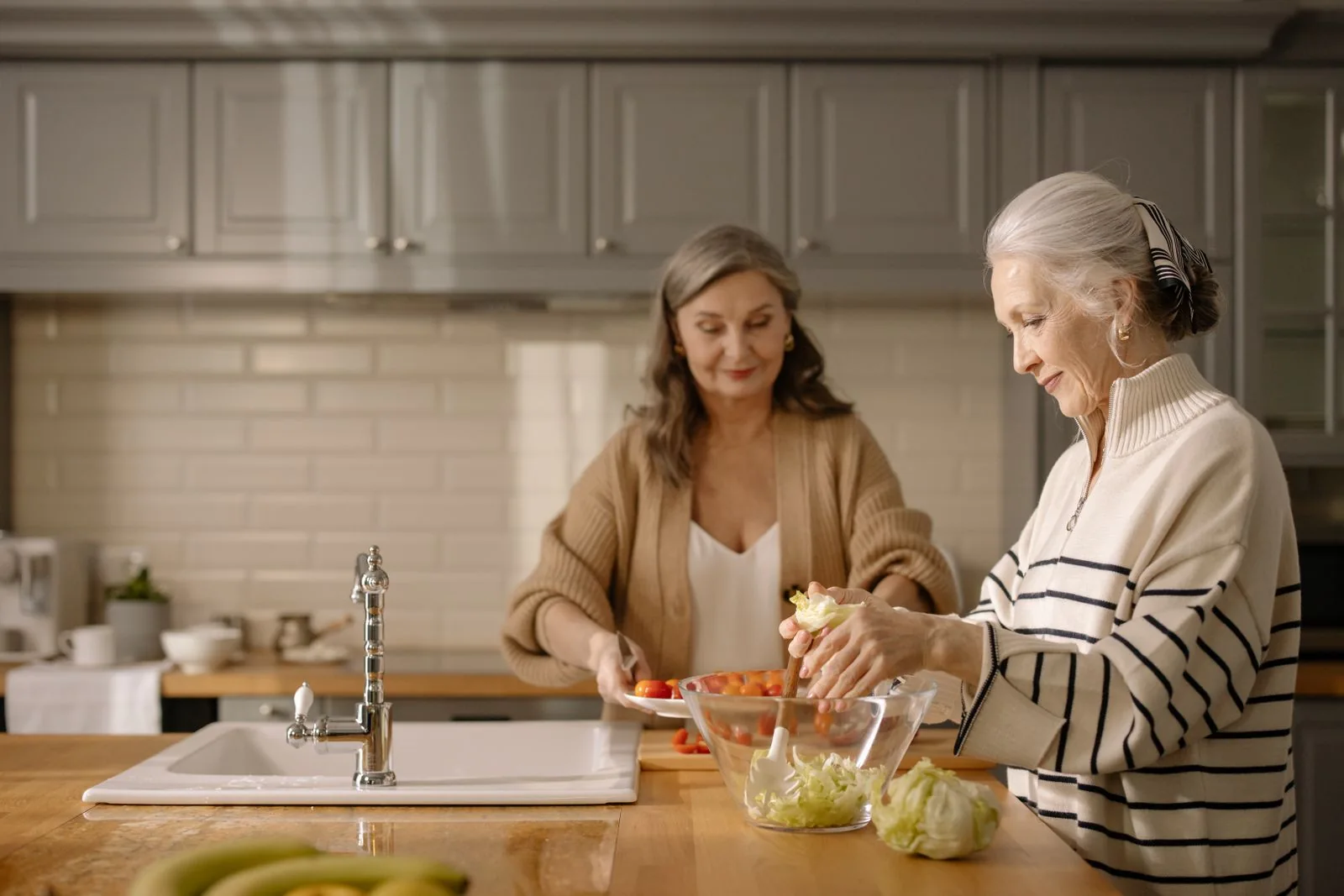 Two women preparing a salad together at home