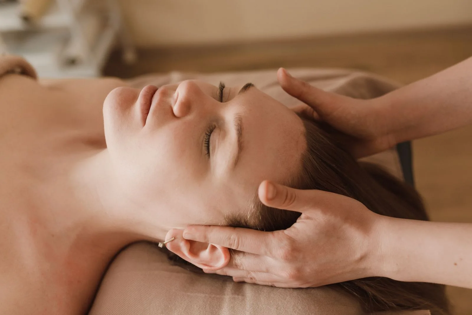 Hands gently massaging the temples during a facial
